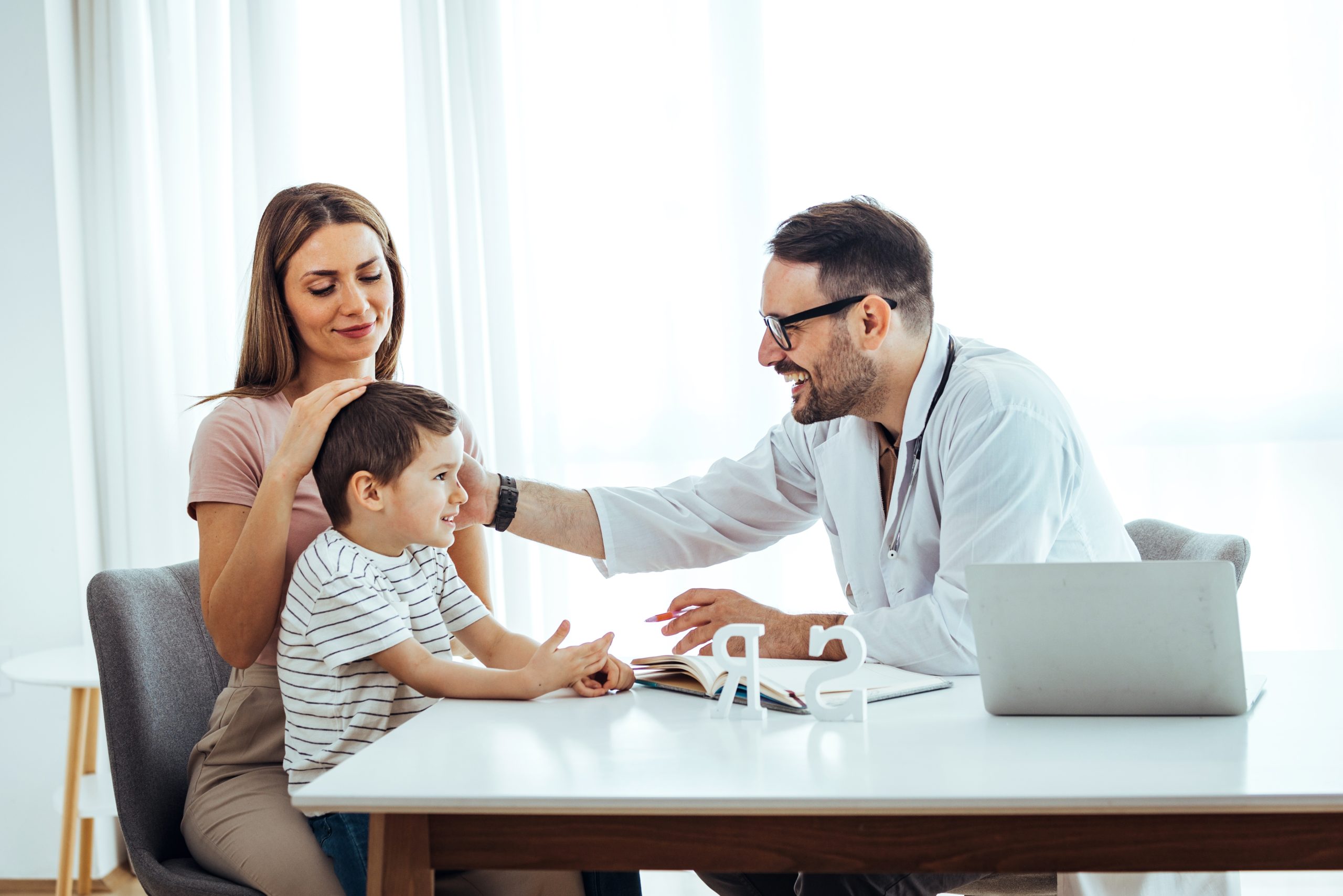 A male doctor helping a mother and her son at the office