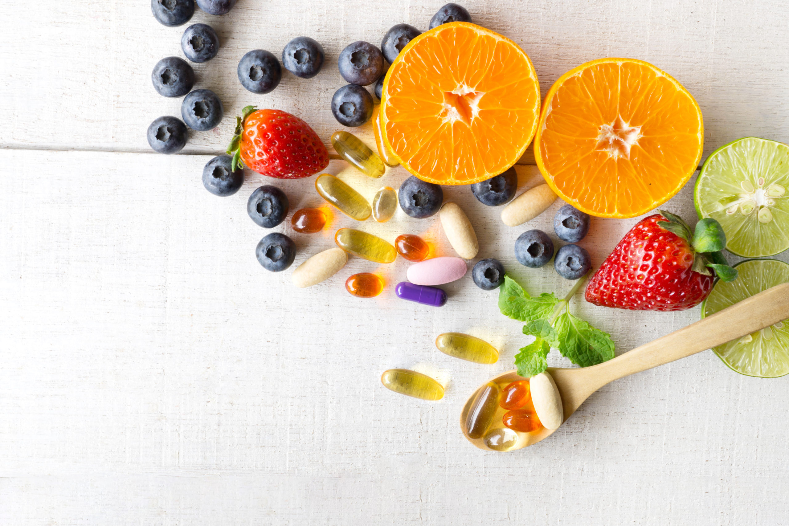 vitamins and supplements next to fresh fruit